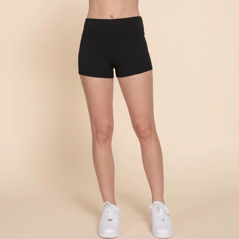 Person wearing black athletic shorts on a beige background